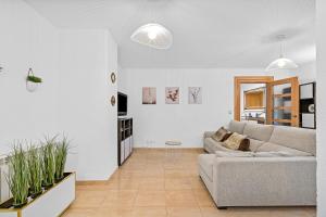 a white living room with a couch and some plants at El rincón de Rosa in Granada