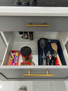 a drawer in a refrigerator filled with kitchen utensils at Stunning Deluxe Studio in Hialeah