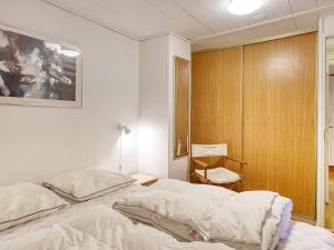 a bedroom with a bed and a wooden cabinet at 6 person holiday home in Dannemare in Nakskov