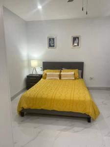 a bedroom with a yellow bed with a yellow blanket at Stunning Deluxe Studio in Hialeah
