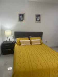 1 dormitorio con 1 cama amarilla con manta amarilla en Stunning Deluxe Studio, en Hialeah