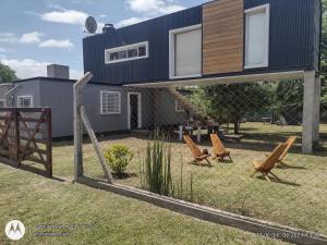 a fence with two chairs and a house at Casa container in Mar del Plata