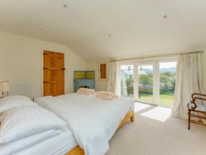 a bedroom with a bed and a large window at Bron Gors in Ederyn