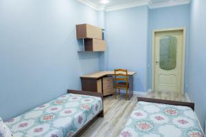 ein Schlafzimmer mit zwei Betten und einem Schreibtisch und einem Stuhl in der Unterkunft Исы Байзакова 131, новостройка in Pawlodar