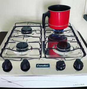 a red pot sitting on top of a stove at Taiba suítes temporada in Acarape