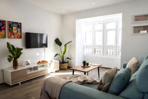 a living room with a blue couch and a tv at Prim 14 by 7Escalones in Rota