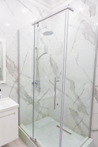 eine Dusche mit Glastür im Badezimmer in der Unterkunft Исы Байзакова 131, новостройка in Pawlodar