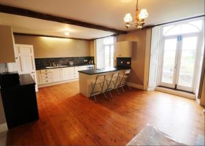 a large kitchen with a counter and stools at Spacious Countryside/Suburban Retreat-Warwickshire in Walsgrave on Sowe
