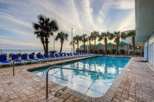 - une piscine avec des chaises bleues et l'océan dans l'établissement Sandy Beach Resort Unit 205, à Myrtle Beach