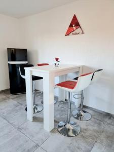 einen weißen Tisch mit 4 Stühlen in einem Zimmer in der Unterkunft Schöne Wohnung auf der Schwäbischen Alb in Münsingen