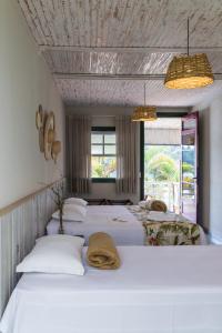 a bedroom with four beds and two windows at Pousada Piratas do Barro Branco in Pedregulho