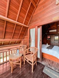 Habitación con cama, mesa y sillas. en Gayatri Bungalows, en Nusa Penida