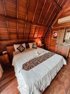 1 dormitorio con 1 cama grande en una habitación de madera en Gayatri Bungalows, en Nusa Penida