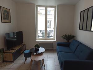 - un salon avec un canapé bleu et une table dans l'établissement Faubourg de la Cueille - Aux portes du Futuroscope, à Poitiers