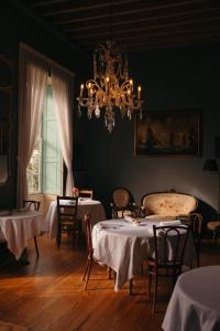a dining room with two tables and a chandelier at Hotel Emblemático La Casa de los Naranjos in Haría