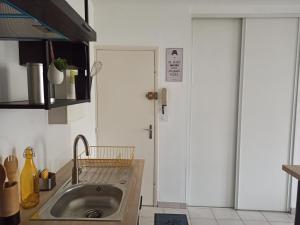uma cozinha com um lavatório e uma porta branca em Faubourg de la Cueille - Aux portes du Futuroscope em Poitiers