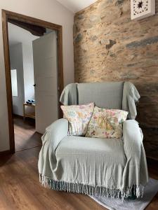 a couch with two pillows on it in a room at A Costa, Valle del Mendo in Oza dos Ríos