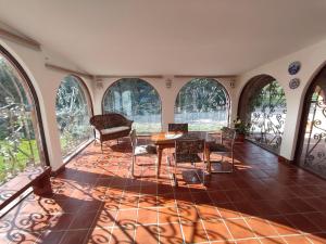 um quarto com uma mesa, cadeiras e janelas em Finca Paraíso Rural em El Burgo de Osma