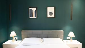 a bedroom with green walls and a bed with two lamps at Matisse No9 - One Bedroom City Center Apartment With Parking in Tirana
