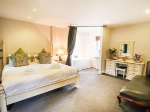 a bedroom with a large bed and a bathroom at The Red in St Asaph