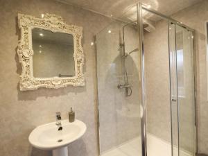 a bathroom with a shower and a sink and a mirror at The Red in St Asaph