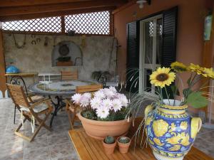 a patio with a table and a vase filled with flowers at Viola di Mare Rooms and Parking in Termoli