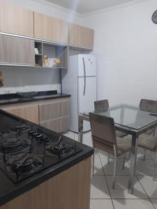 Il comprend une cuisine équipée d'une cuisinière, d'une table et d'un réfrigérateur. dans l'établissement Casa Al Mare, à Itanhaém
