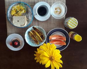 uma mesa com pratos de comida e uma flor amarela em Pousada Céu de Corumbau em Corumbau
