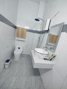 a white bathroom with a sink and a toilet at Nhà nghỉ Bonne Vie' Homestay in Can Tho