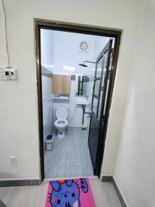 a bathroom with a toilet and a rug on the floor at Nhà nghỉ Bonne Vie' Homestay in Can Tho
