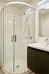 a bathroom with a shower and a sink at Sojourn Apartment Hotel - Ghuznee in Wellington
