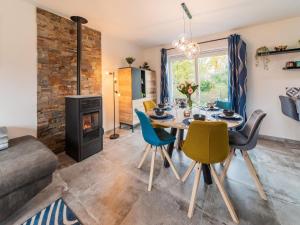 een eetkamer met een tafel en stoelen en een open haard bij Modern holiday home in Noiseux with fenced garden in Noiseux