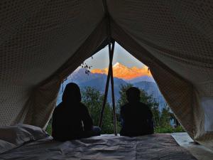 two people sitting in a tent looking at the mountains at Khwaab in Munsyari