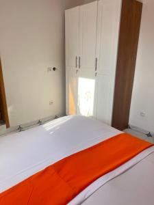 een slaapkamer met een oranje deken op een bed bij Studio meublé Cosy in Douala