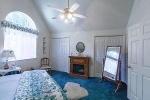 a bedroom with a bed and a mirror and a ceiling fan at Cedar Haven - A Hiker's Retreat in Mariposa