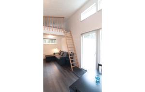 a living room with a staircase and a living room with a couch at Amazing Home In Gotlands Tofta With 2 Bedrooms in Västergarn