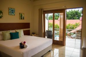 1 dormitorio con 1 cama y puerta corredera de cristal en Colina de Montalva Casa Hotel, en Tarapoto