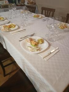uma mesa com pratos de comida numa toalha de mesa branca em Lu Renge em Fiaiola