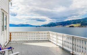 a balcony of a house with a view of the water at 5 Bedroom Amazing Home In Strandebarm in Strandebarm +25 photos