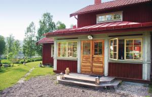 a red house with a wooden door and a porch at Nice Home In Jrvs With Sauna in Järvsö