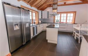 a large kitchen with stainless steel appliances and wooden ceilings at Nice Home In Jrvs With Sauna in Järvsö