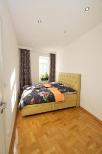 Schlafzimmer mit einem Bett und Holzboden in der Unterkunft Lux Apartments Prestige in Wien