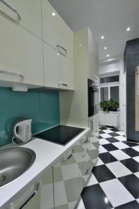 a kitchen with a sink and a black and white checkered floor at Lux Apartments Prestige in Vienna