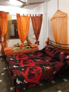 a bedroom with a bed with red sheets and roses at Villa Carimo in Quseir