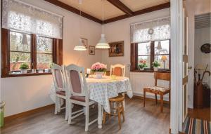 comedor con mesa, sillas y ventanas en Beautiful Home In Mullsj With Kitchen en Mullsjö