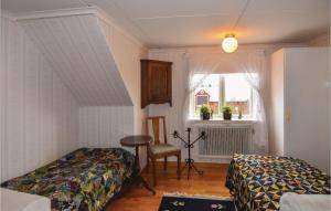 a bedroom with two beds and a table and a window at Beautiful Home In Mullsj With Kitchen in Mullsjö