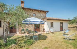 a patio with chairs and an umbrella in front of a house at La Dependance in Migliano