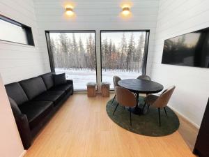 a living room with a black couch and a table at Arctic Iglu Levi in Sirkka