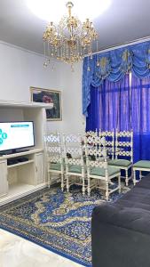 sala de estar con lámpara de araña y cortinas azules en Apartamento conforto e requinte!, en São Paulo