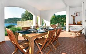 a dining room with a table and chairs on a patio at Beautiful Home In Kanica With Kitchen in Sevid
